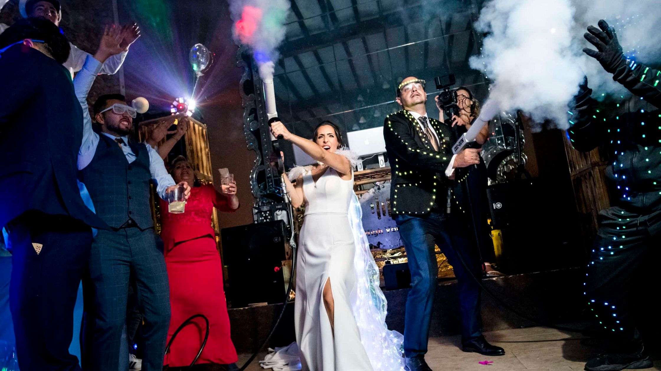 Una pareja de novios luciendo accesorios de hora loca, un tipo de animación para bodas que en tendencia en los últimos años